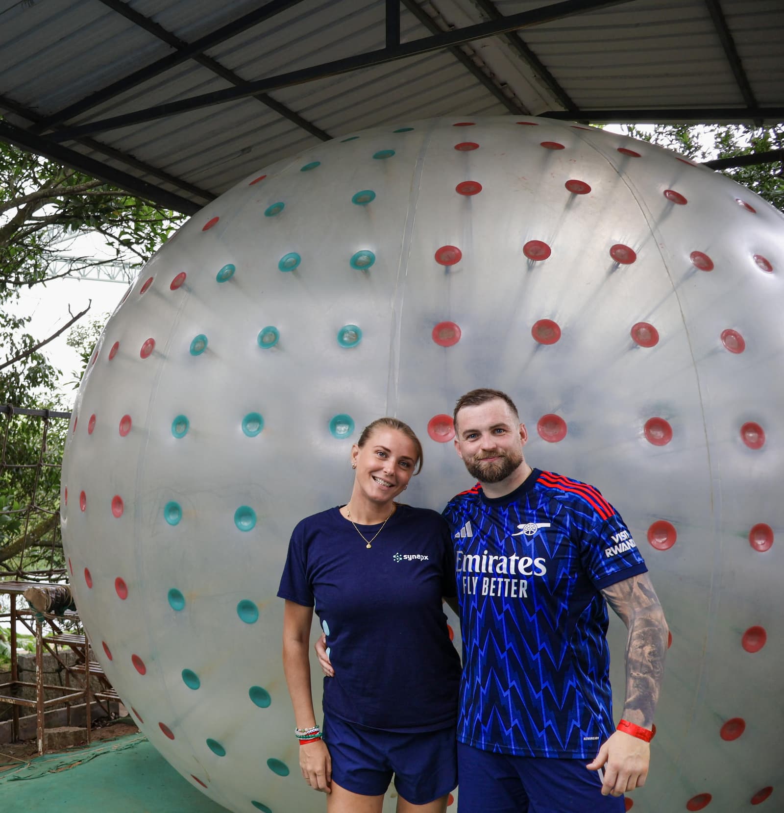 Two team members in front of a giant zorb ball