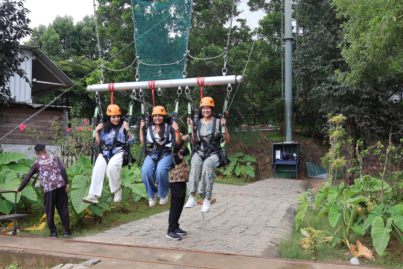 Three teammates harnessed up for the giant swing