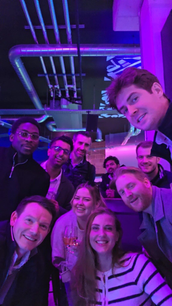 Group selfie at a bar with neon lighting