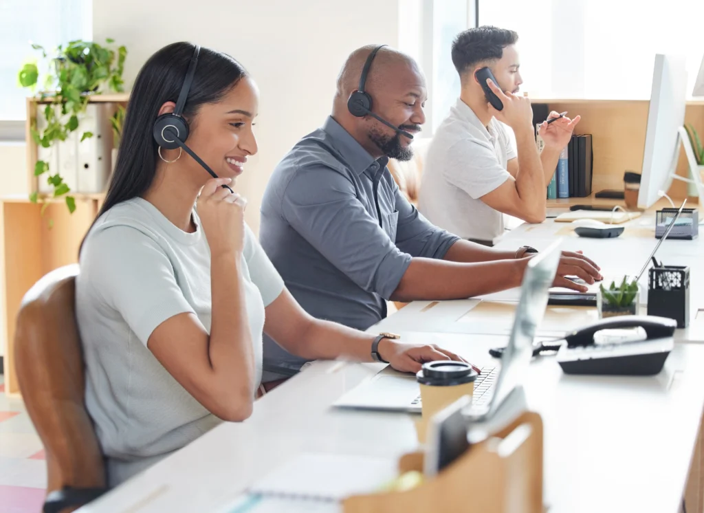 Hr Employees managing multiple support requests sat on desks with laptops.